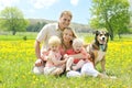 Portrait of Happy Family and Dog in Flower Meadow Royalty Free Stock Photo