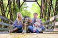 Portrait of Happy Family and Dog Sitting On Bridge in Autumn Woo Royalty Free Stock Photo