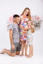 Portrait of a happy family father, pregnant mother, little daughter having fun together isolated over white with floral background Royalty Free Stock Photo