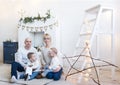 Portrait of happy family of four sitting on floor in white room at home Royalty Free Stock Photo