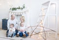 Portrait of happy family of four sitting on floor in white room at home Royalty Free Stock Photo