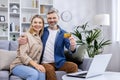 Portrait of happy family at home, adult mature couple man and woman sitting on sofa in living room and looking Royalty Free Stock Photo