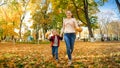 Portrait of happy family with little boy wlking in autumn park Royalty Free Stock Photo