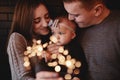 Portrait of happy family, mom, dad and baby girl with sparklers in front. family in anticipation of Christmas Royalty Free Stock Photo