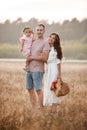 Portrait of happy family. Mom, dad and daughter walk in the field. Young family spending time together on vacation Royalty Free Stock Photo