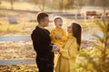 Portrait of happy family. Mom, dad hugging daughter in autumn park. Young couple spending time together on vacation, outdoors. The Royalty Free Stock Photo