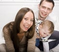 Portrait of happy family, mom and dad playing with their son in bed Royalty Free Stock Photo