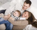 Portrait of happy family, mom and dad playing with their son in bed Royalty Free Stock Photo