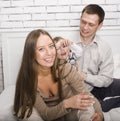 Portrait of happy family, mom and dad playing with their son in bed Royalty Free Stock Photo