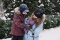 Portrait of happy family mother, son and cat in snowy winter park. Outdoors Portrait of mom and kid boy with cat hugging Royalty Free Stock Photo