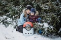 Portrait of happy family mother, son and cat in snowy winter park. Outdoors Portrait of mom and kid boy with cat hugging Royalty Free Stock Photo