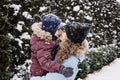 Portrait of happy family mother and son in snowy winter park. Outdoors Portrait of mom and kid boy hugging in winter Royalty Free Stock Photo