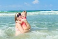 Portrait of Happy family - mother with toddler daughter in sun protecting swimming suit having fun fun in sea pool. Healthy lifest