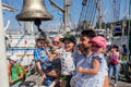 Portrait of happy family near by ship bell of sailboat `Pallada`
