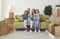 Happy family with children sitting on couch in their new home and giving thumbs up Royalty Free Stock Photo