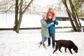 Portrait of happy family with one kid and dog in winter casual outfit posing outdoors Royalty Free Stock Photo