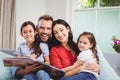 Portrait of happy family with picture book on sofa Royalty Free Stock Photo