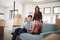 Portrait Of Happy Family Resting On Sofa Surrounded By Boxes In New Home On Moving Day Royalty Free Stock Photo