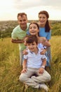 Portrait of a happy family sitting on nature in the grass. Royalty Free Stock Photo