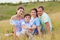 Portrait of a happy family sitting on nature in the grass. Royalty Free Stock Photo