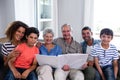 Portrait of happy family sitting on sofa and looking at photo album Royalty Free Stock Photo