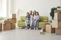 Portrait of a happy family sitting on a sofa in their new apartment on a moving day Royalty Free Stock Photo