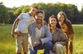Portrait of happy family with son and daughter sitting in the summer park and looking at camera. Royalty Free Stock Photo