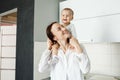 Portrait of happy family spending precious time together in weekend morning.Mother holds her son on shoulders while he Royalty Free Stock Photo