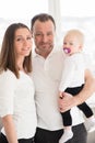 Portrait of happy family of three. Parents with their beautiful baby girl at home. Royalty Free Stock Photo