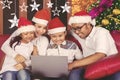 Happy family using a laptop at Christmas time Royalty Free Stock Photo