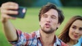 Portrait of happy family using smartphone for video chat in meadow