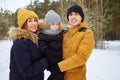 Mom and dad are cuddling and kissing their little son in winter park. Royalty Free Stock Photo