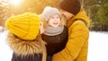 Mom and dad are cuddling and kissing their little son in winter park. Royalty Free Stock Photo