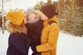 Mom and dad are cuddling and kissing their little son in winter park. Royalty Free Stock Photo