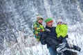 Portrait of a happy family in winter park. Father, son and little daughter laughing Royalty Free Stock Photo