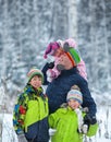 Portrait of a happy family in winter park. Father, son and little daughter laughing Royalty Free Stock Photo