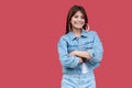 Portrait of happy fancy beautiful brunette young woman with makeup in denim casual style standing with crossed hands and looking Royalty Free Stock Photo