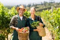 Portrait of happy farmer couple holding baskets of vegetables Royalty Free Stock Photo