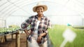 Portrait of a happy farmer in a garden. Young farmer standing in a greenhouse. African american farmer working in her