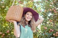Portrait of a happy farmer holding a basket of freshly picked apples in an orchard outside on a sunny day. Cheerful Royalty Free Stock Photo
