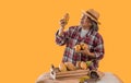 Portrait of happy farmer senior man standing holding and looking at fresh cacao fruit with isolated on yellow background Royalty Free Stock Photo