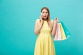 Portrait of happy fashion caucasian woman with shopping bags calling on mobile phone. Isolated on blue background. Royalty Free Stock Photo