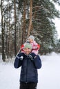 Portrait of happy father and baby toddler daughter on winter nature background. Man and baby girl on his shoulders in Royalty Free Stock Photo