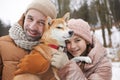 Portrait of Happy Father and Daughter Playing with Dog in Winter Royalty Free Stock Photo