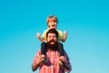 Portrait of happy father giving son piggyback ride on his shoulders. Cute boy with dad playing outdoor. Kid son hugging Royalty Free Stock Photo