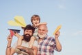 Portrait of happy father giving son piggyback ride on his shoulders and looking up. Male multi generation portrait Royalty Free Stock Photo