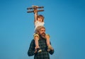 Portrait of happy father giving son piggyback ride on his shoulders and looking up. Two generations of men father and Royalty Free Stock Photo