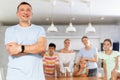 Portrait of happy father of large family against the background of children and his wife in interior of his house