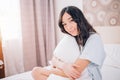 Beautiful Positive woman sitting in bed in morning Royalty Free Stock Photo