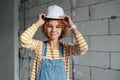 Portrait of a happy female construction engineer putting on a white helmet